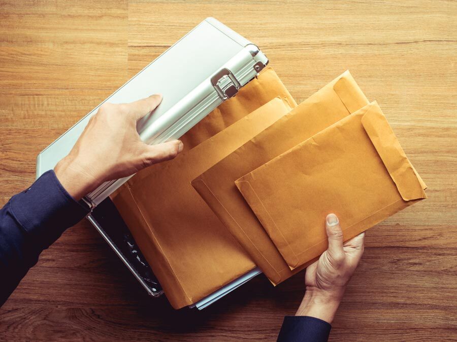 Ein Mann legt Unterlagen und Dokumente in eine sichere Mappe.