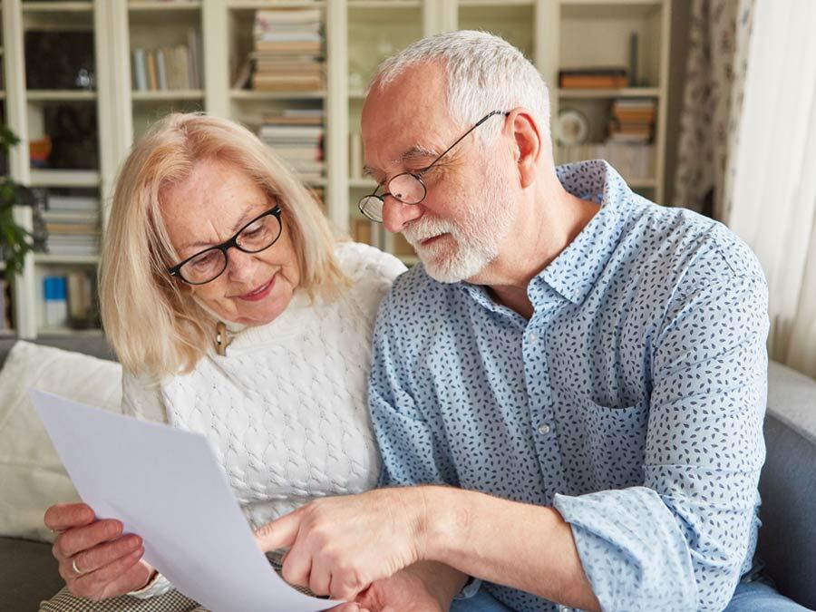 Ein älteres Paar schaut sich zusammen ein Formular Patientenvollmacht an.