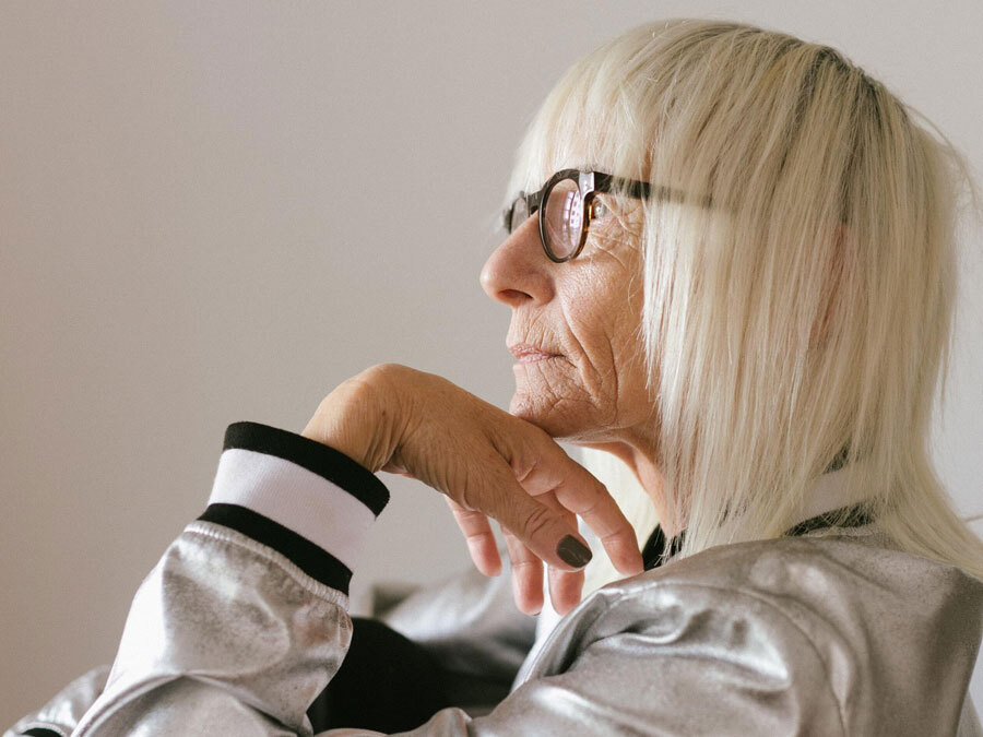 Eine Dame schaut nachdenklich in die Ferne. Sie interessiert sich für das Thema vorweggenommene Erbfolge.