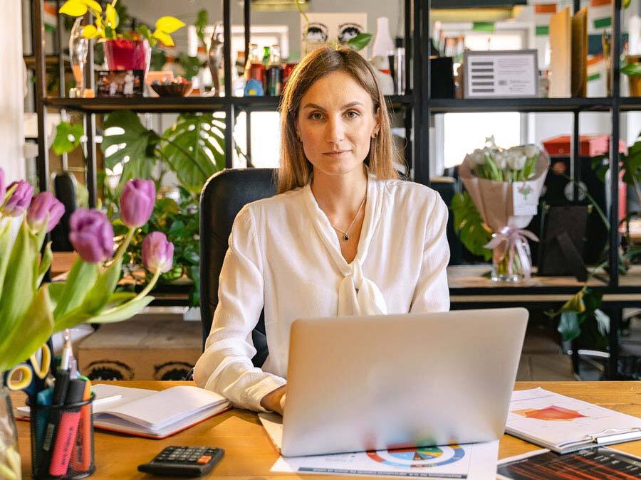 Eine Frau im Homeoffice sitzt vor dem Rechner. Sie plant den Tagesablauf.