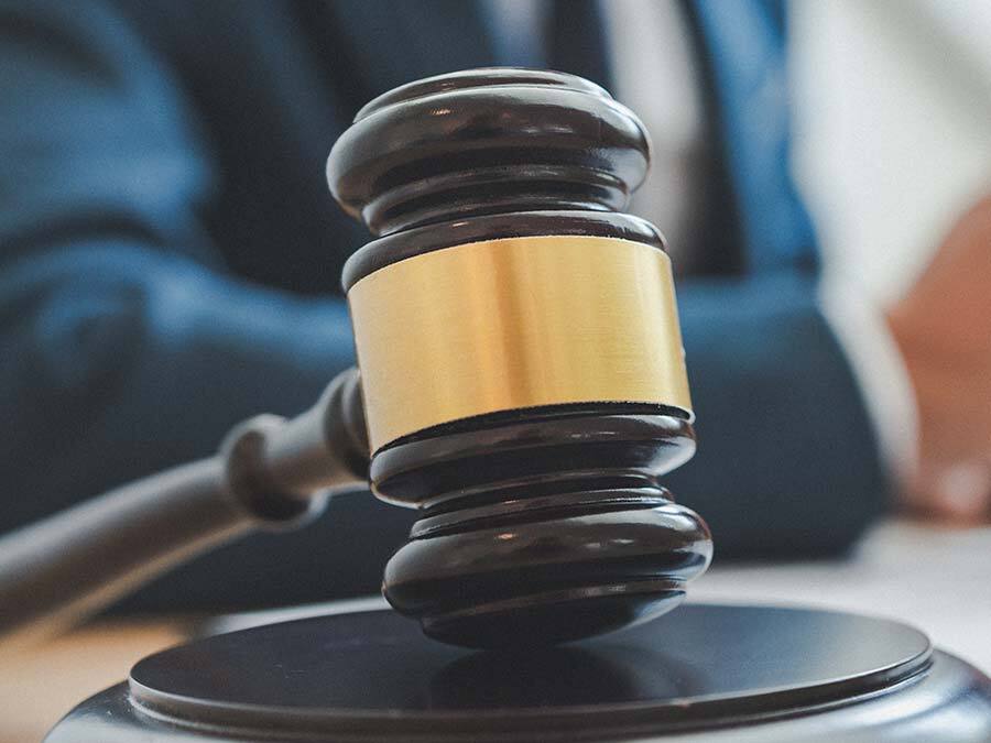 Ein Richterhammer symbolisiert, dass der Streit um den Entzug des Pflichtteil oft vor Gericht endet.