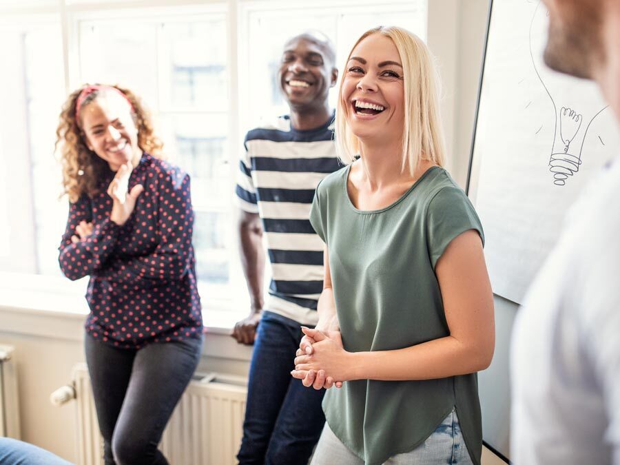 Ein kreativer Prozess findet bei vier Mitarbeitenden vor einem Flipchart statt